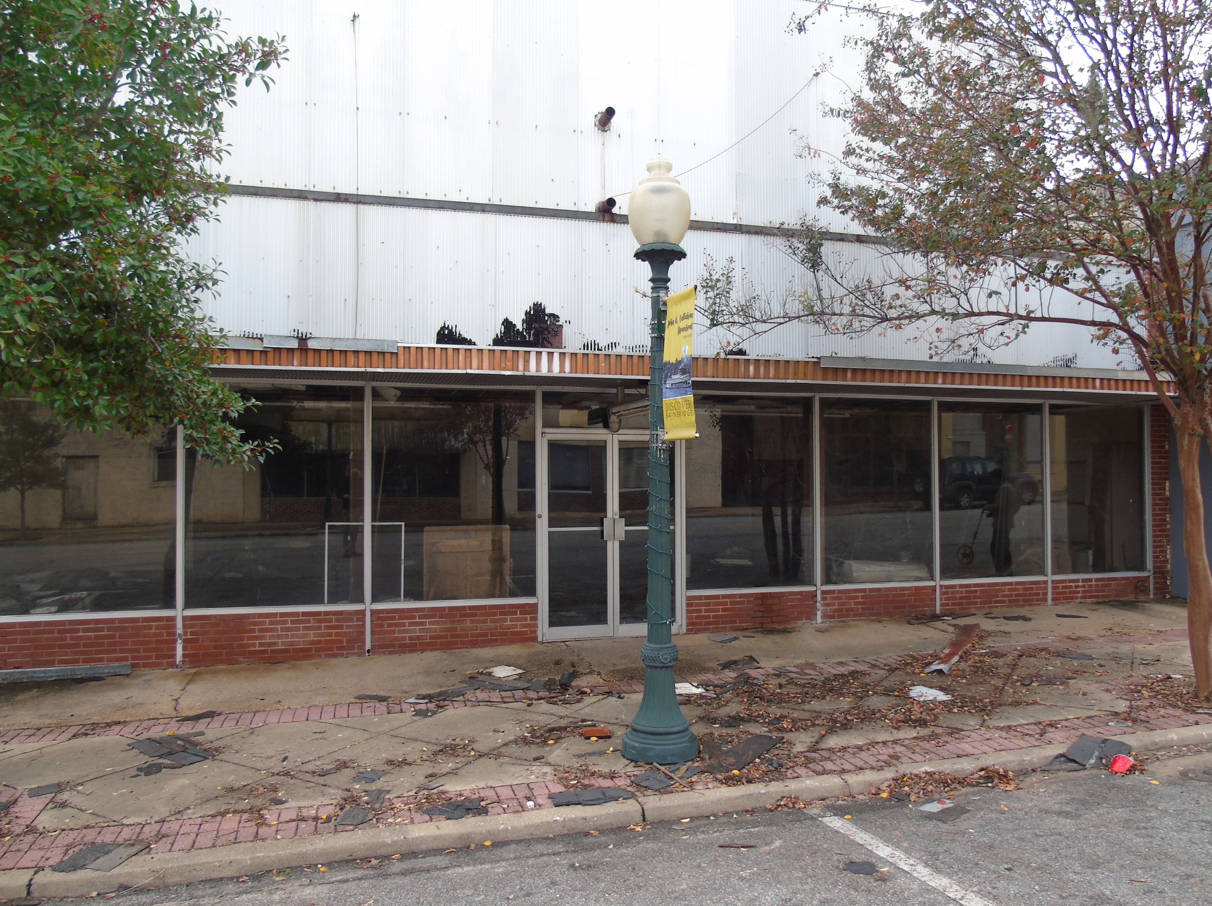 Glass structures fit in between trees in an urban courtyard.