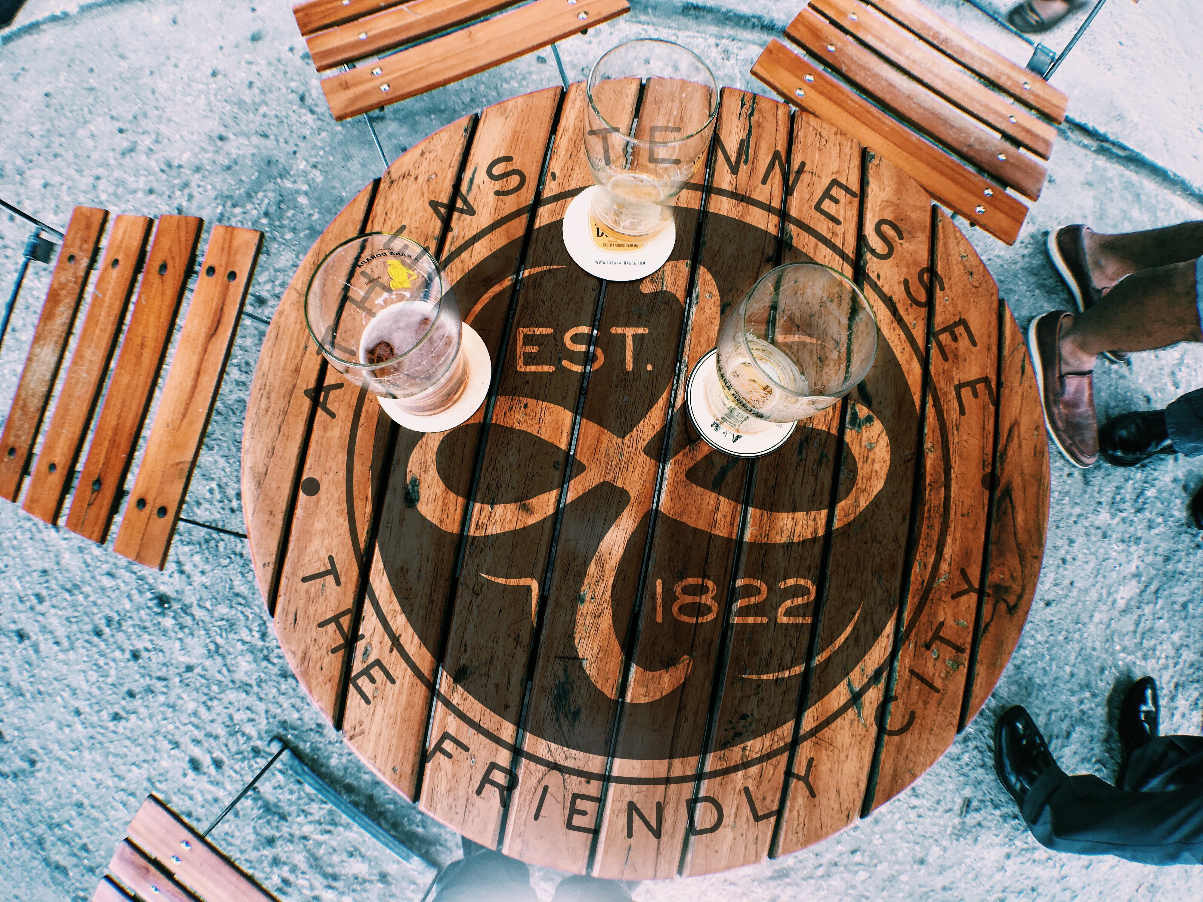 Athens, TN logo burned into a cutting board design. Drinks rest on the board.