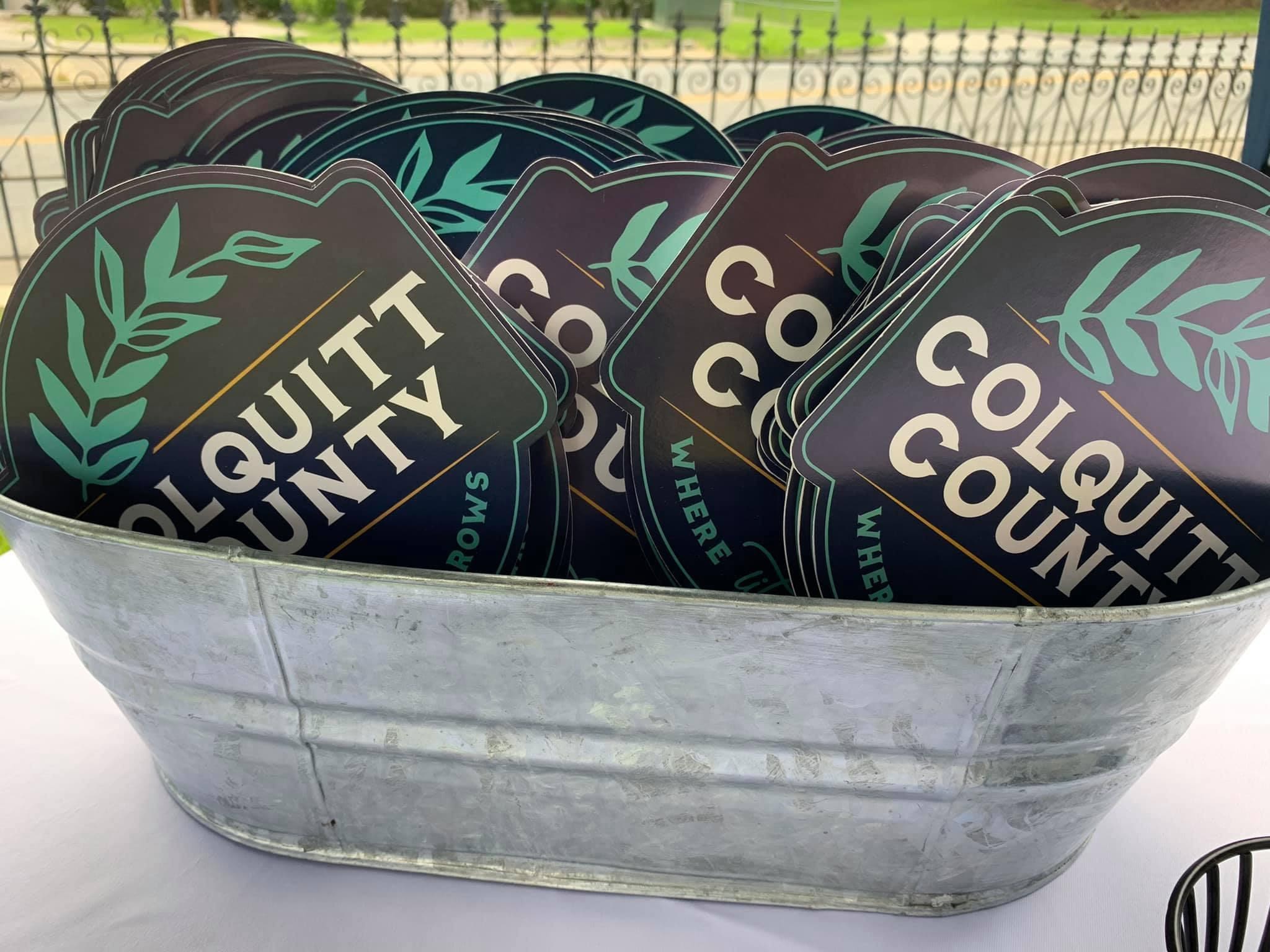 A metal bin holds stickers with the new brand for Colquitt County